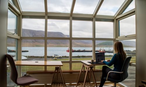 Woman working on laptop with Iceland backdrop